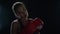 Woman fighter preparing for sport workout in dark gym. Portrait of woman boxer