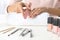 Woman filing nails covered with polish at table