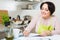 woman filling banking documents and smiling in kitchen