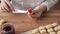 Woman filling Christmas cookies with strawberry jam