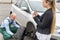 Woman filling document while mechanic changing wheel