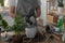 Woman filling flowerpot with drainage at table indoors, closeup. Houseplant care