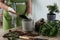 Woman filling flowerpot with soil at table indoors, closeup. Houseplant care