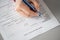 Woman filling hotel reservation form putting first name. Reception desk. Hotel service, registration. Close up. Selective focus.