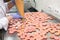 Woman Filling Pink Macarons Shells With Ganache