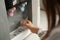 Woman filling plastic cup with water from cooler, closeup