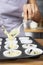 Woman filling up the muffin liners on baking tray. Conceptual image