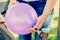 Woman filling violet balloon with helium