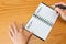 Woman fills in her goals and plans for long and short terms in spiral notepad on wooden table, top view