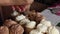 A woman fills waffle cones with chocolate mixture for homemade ice cream. Close-up