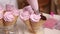 A woman fills waffle cones with marshmallows. With a pastry bag. Close-up