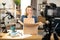 Woman filming on camera unpacking process of paper box