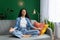 A woman finds peace as she meditates on a couch in her serene living room