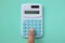 Woman Finger press green calculator on green pastel background