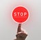 Woman Finger Pushing red round stop sign
