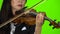 Woman fingering the strings playing violin. Close up. Green screen