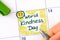 Woman fingers with green pen writing reminder World Kindness Day in calendar
