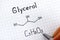 Woman fingers with pen writing chemical formula of Glycerol