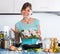 Woman with fish and frying pan at kitchen