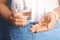 Woman with fish oil pills and glass of water