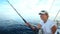 Woman fishing with rod on sailboat at sea