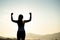 Woman with fist in the air during sunset sunrise mountain in background. Stand strong. Feeling motivated, freedom, strength and