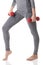 A woman fit legs, body, hands in gray sports thermal underwear doing exercises using red dumbbells.