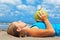 Woman fitness exercise with green coconuts on ocean beach