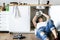 Woman fixing kitchen sink at home