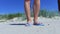 Woman in flip flops on sandy beach