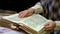 A woman flips through the pages of an old book