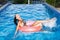 Woman floating in inner tube in pool and having fun