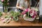 Woman florist create flower arrangement in a wicker basket. Beautiful bouquet of mixed flowers. Floral shop concept