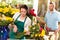 Woman florist cutting flowers shop bouquet man