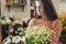 Woman florist holds a large beautiful bouquet of blooming white daisies in flower shop