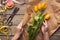 Woman florist making tulips bouquet on wooden table