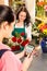 Woman florist selling flowers customer paying card