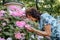 Woman with a flower. Senior Hispanic Woman Working In Garden. Close-up portrait of an older woman on walk with flowers.