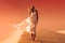 Woman in fluttering dress. Desert and sand dunes. Red sky.