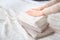 Woman folding clean towels on bed,