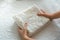 Woman folding white laundry and towels in bedroom, organizing clothes