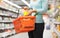 Woman with food basket and jar at grocery store