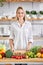 woman food blogger engaged in process of preparing food in kitchen from fresh vegetables