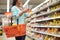 Woman with food in shopping basket at supermarket