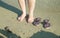 Woman foot and  brown pair of sandals on the beach