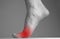 Woman foot with pain in ball with red point closeup. Intense physical activity, inflammation consequences. Health care