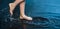 Woman foot step on blue Water in Splash