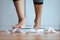 Woman foot stepping on weigh scales with tape measure in foreground,Weight loss,Body and good health concept