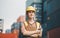 Woman Foreman in hardhat and safety vest holding clipboard checklist and two-way radio aat containers cargo