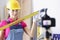 Woman foreman repairman in protective helmet holding ruler in front of camera